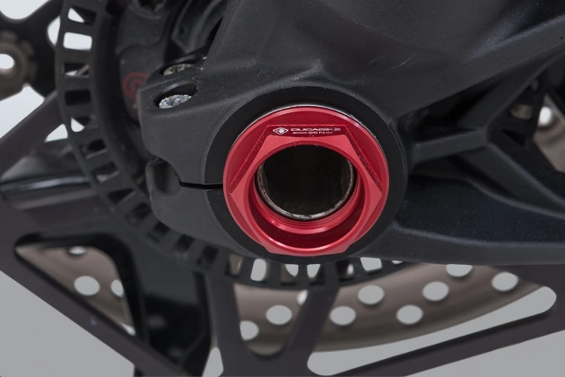 Close-up view of a red anodised wheel nut on the front wheel