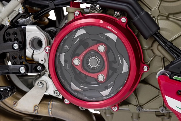 Close-up view of clutch with red anodised clutch cover with viewing window, black pressure plate and red spring plate with the inscription "CNC Racing"